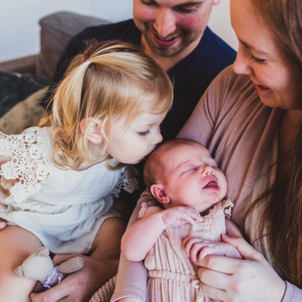 arrival of a sibling disrupts sleep, toddler kissing new baby