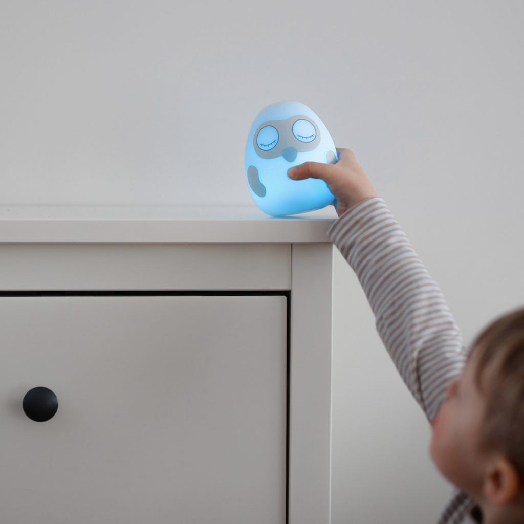 Boy putting Ooly sleep clock on the shelf